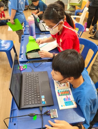 Children working together with laptops and electronics kits