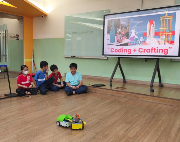 Students watching their coded robot move during a group demonstration