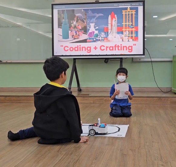 A student presenting a robotics project during a Coding and Crafting session