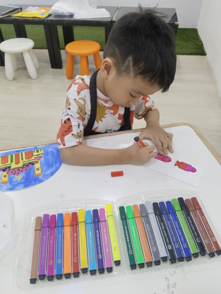 A child assembling and decorating a detailed craft project