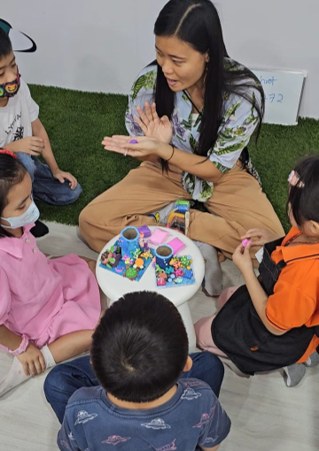 An instructor guiding children through a hands-on craft activity